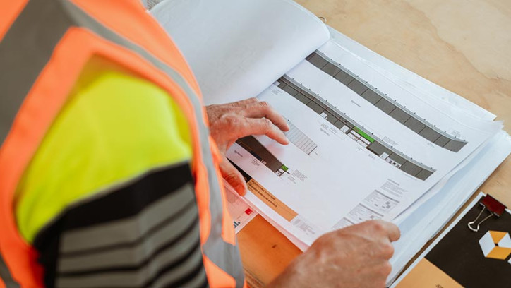 Person in hi-vis vest reading documents